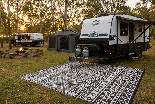 Camping rug beside caravan showing comfortable outdoor camping setup