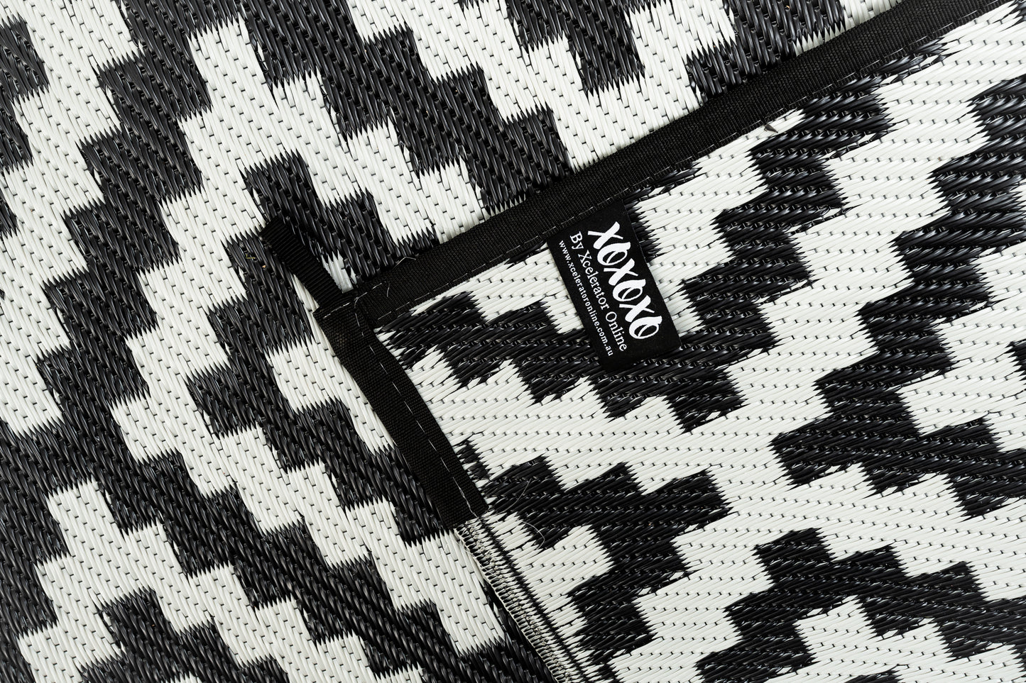 Black and grey outdoor rug used for camping caravan setup