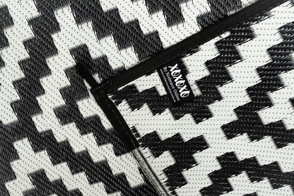 Black and grey outdoor rug used for camping caravan setup
